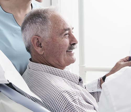 An elderly man at the dentist smiling